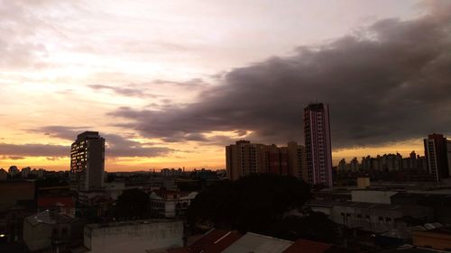 Buildings in city against cloudy sky