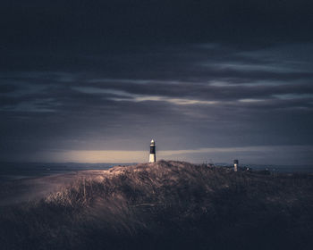 Lighthouse by sea against sky