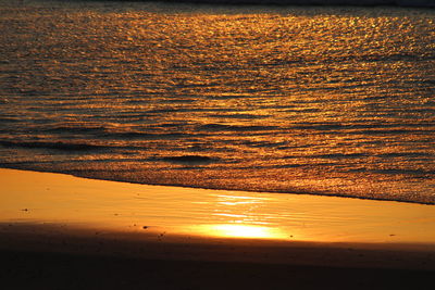 Close-up of beach against sky during sunset