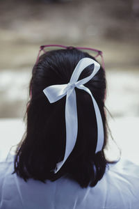 Rear view of woman hair tied with ribbon