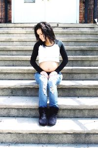 Full length of woman sitting outdoors
