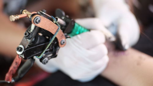 Cropped image of artist tattooing person