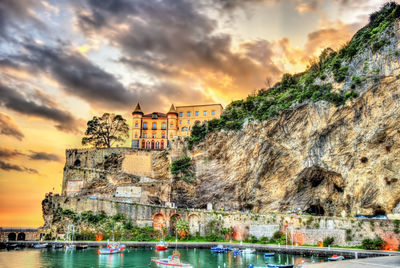 Buildings at waterfront during sunset