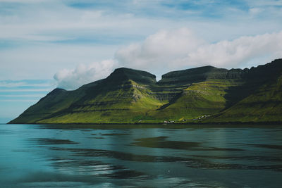 Scenic view of sea and mountains against sky