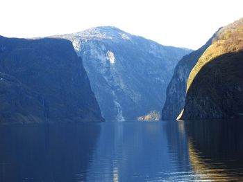 Scenic view of lake by mountains against sky