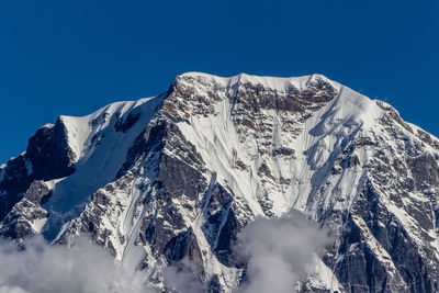 Scenic view of snowcapped mountains against clear blue sky