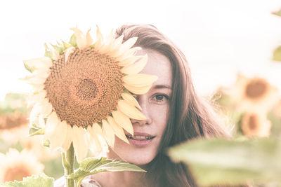 Portrait of woman against sunflower