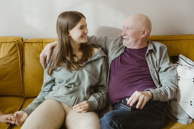 Friends sitting on sofa at home