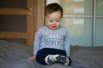 Boy sitting on bed at home