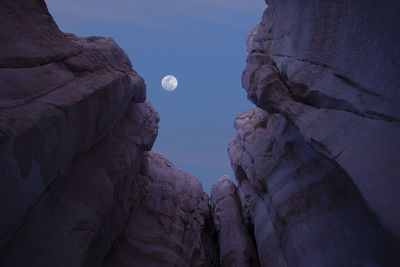 Low angle view of rocks against sky at dusk