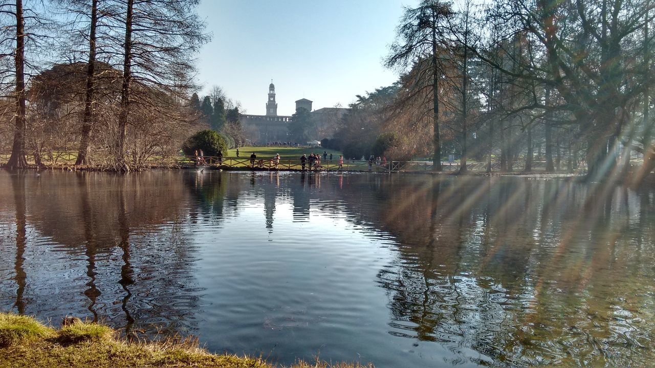 tree, water, reflection, built structure, architecture, nature, outdoors, lake, day, beauty in nature, building exterior, tranquil scene, travel destinations, tranquility, scenics, sky, no people