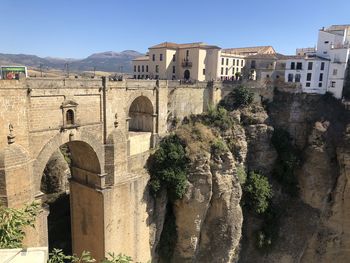 Arch bridge in city against clear sky
