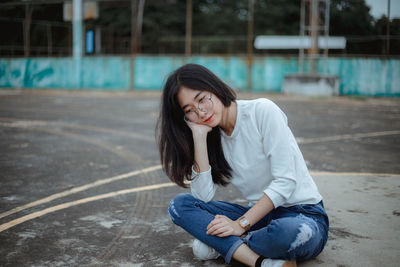 Young woman sitting on basketball court