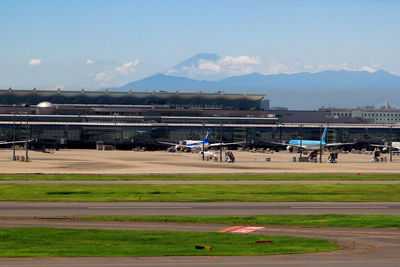 Airplanes at narita international airport against sky