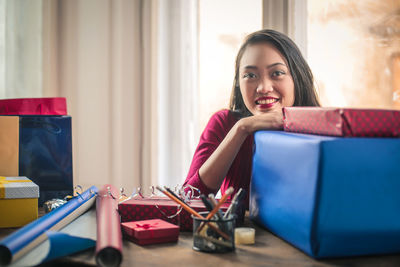 Portrait of smiling young woman sitting on table