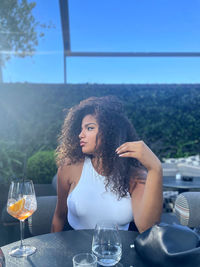 Portrait of smiling young woman drinking glass