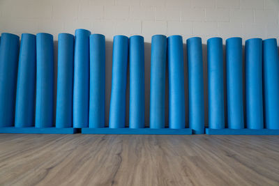  pilates rolls standing on wooden oak floor against the white brick wall. low angle view, concept.