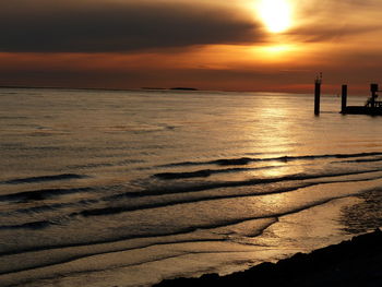 Scenic view of sea against orange sky