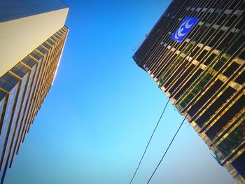 Low angle view of modern buildings against clear blue sky