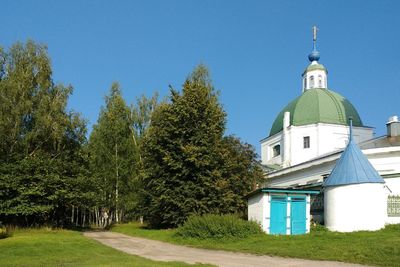 Trees and building against blue sky