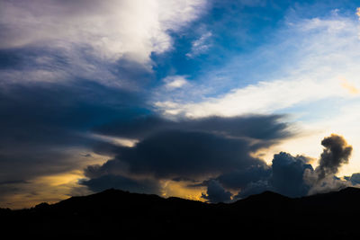 Low angle view of silhouette mountains against dramatic sky