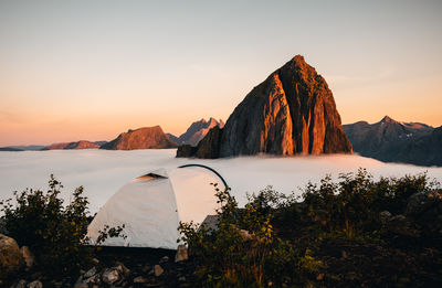 Scenic view of tent in senja sunset aligns with mount segla. ideal for travel and scenic projects. 