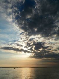 Scenic view of sea against cloudy sky at sunset