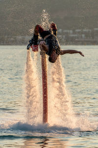 Man flyboarding in sea