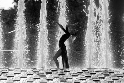 Side view of a man splashing water fountain