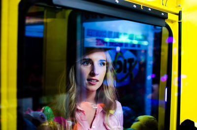 Young woman looking through window