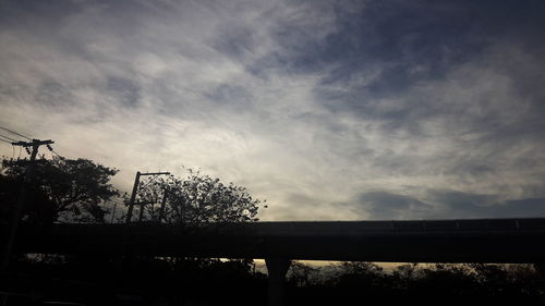 Low angle view of silhouette trees against sky