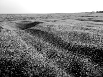 Close-up of sand on beach against clear sky