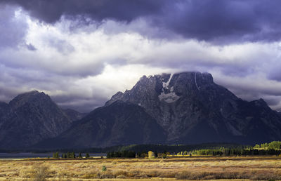 Scenic view of field and mountains against sky