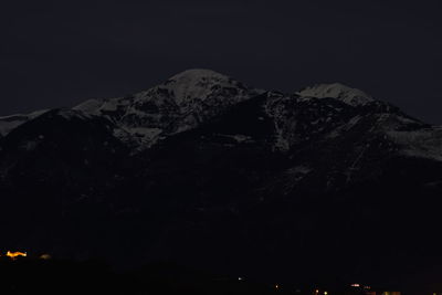 Low angle view of snowcapped mountain against sky at night