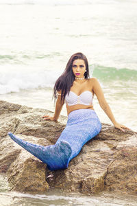 Full length portrait of young woman on beach