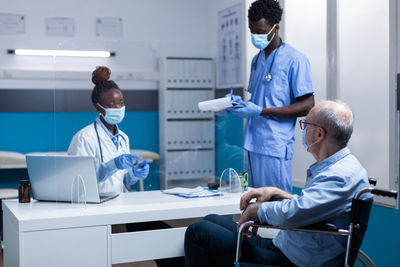 Doctor wearing mask talking at hospital