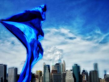 Low angle view of skyscrapers against cloudy sky