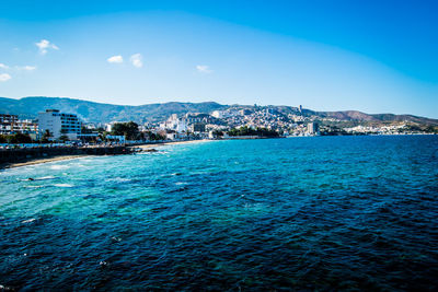 Scenic view of sea by city against sky