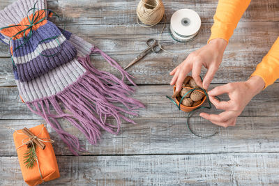 High angle view of woman tying walnuts in bowl on table