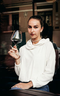 Portrait of a woman holding drink in restaurant