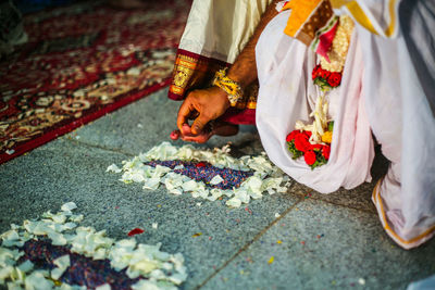 Low section of couple performing rituals during wedding ceremony