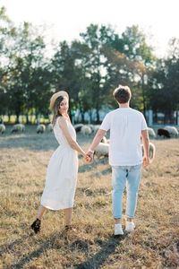 Rear view of couple standing on field