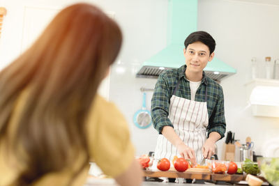 Happy woman standing by fruits at home