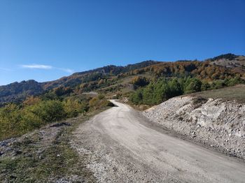 Road amidst landscape against clear blue sky