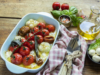Baked vegetable tomato, basil, mozzarella cheese, garlic in the oven in ceramic dishes.  cooked dish