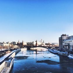 Frozen canal water against city buildings