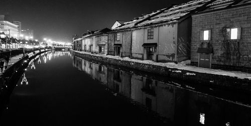 Buildings reflecting in canal at night during winter