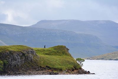 Scenic view of sea and mountains against sky