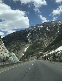 Road amidst snow-dusted mountains