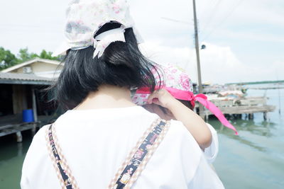 Rear view of woman standing against sky